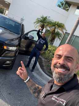 Cliente satisfeito com a compra do carro nos EUA, ao lado do David